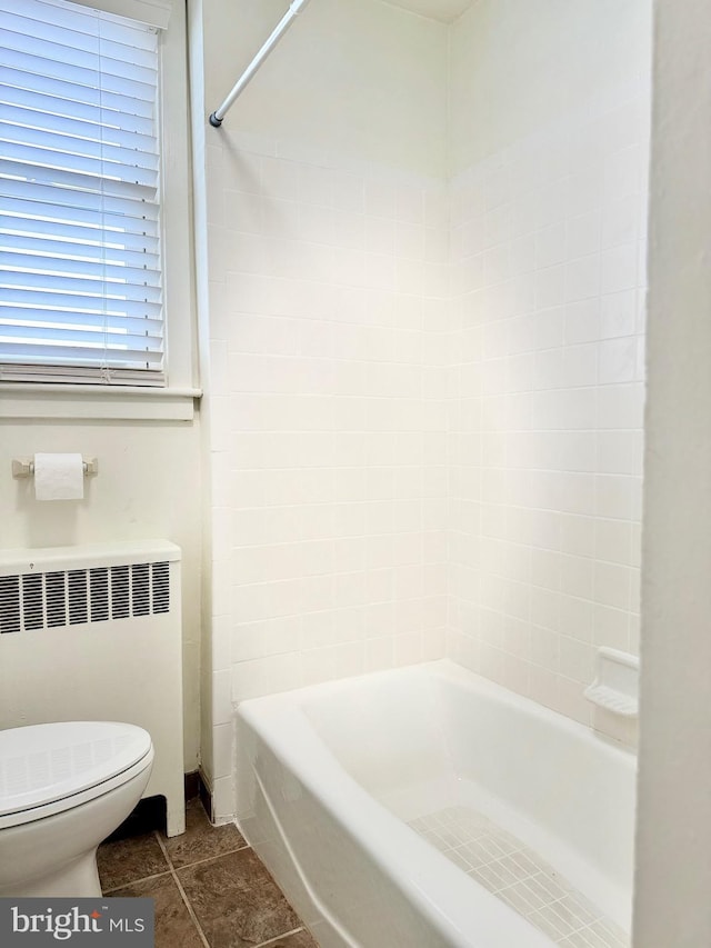 bathroom featuring toilet, radiator, and shower / washtub combination