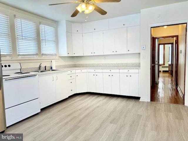 kitchen with white electric range, white cabinetry, and radiator heating unit