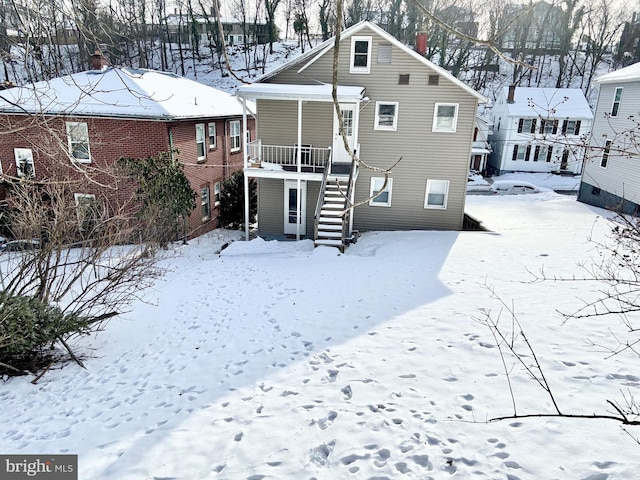 view of snow covered back of property