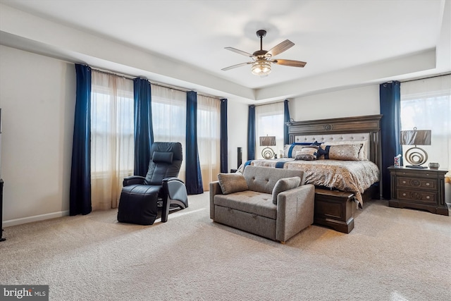 carpeted bedroom with ceiling fan and baseboards