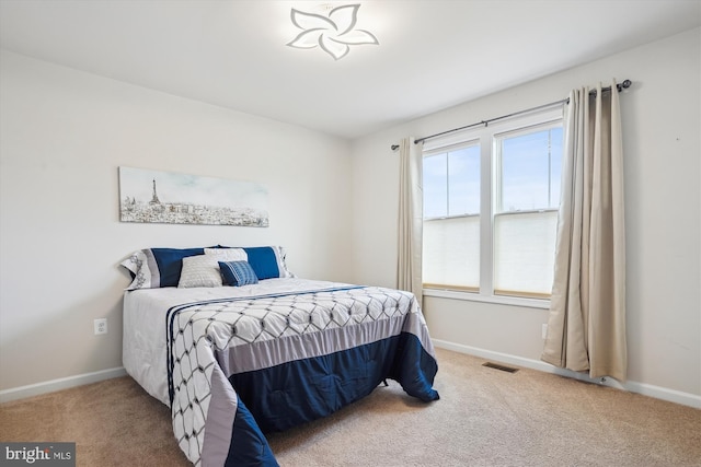 carpeted bedroom featuring visible vents and baseboards