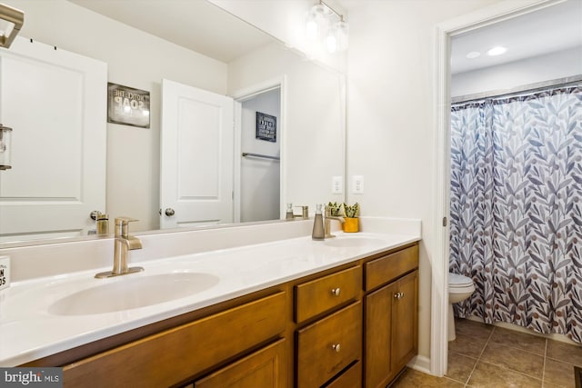 full bathroom with double vanity, toilet, a sink, and tile patterned floors