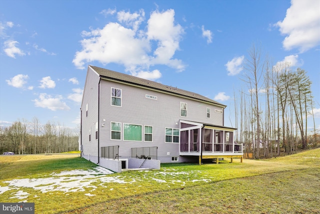 rear view of house with a sunroom and a lawn