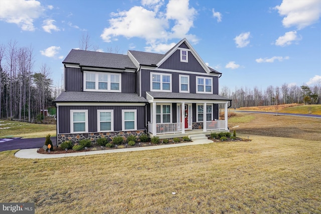 craftsman-style home with covered porch, stone siding, a front lawn, and board and batten siding