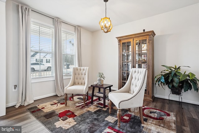 sitting room with an inviting chandelier, baseboards, and wood finished floors