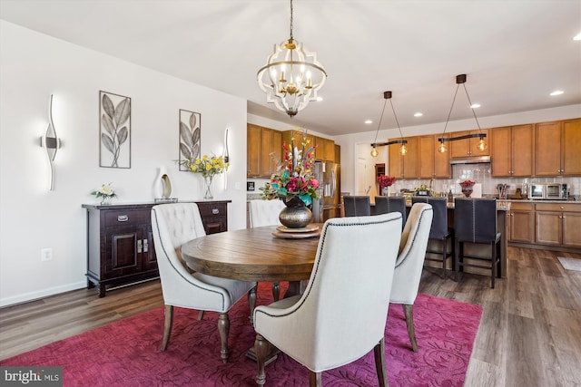 dining area with dark wood-style floors, baseboards, a notable chandelier, and recessed lighting