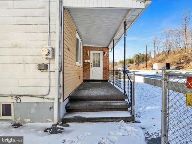 snow covered property entrance featuring covered porch