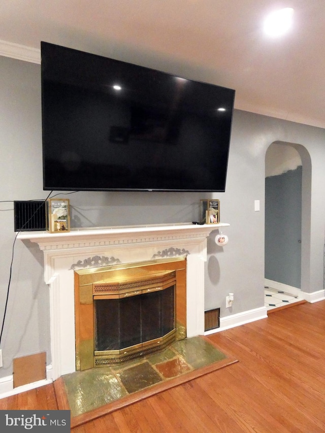 interior details with ornamental molding and hardwood / wood-style flooring