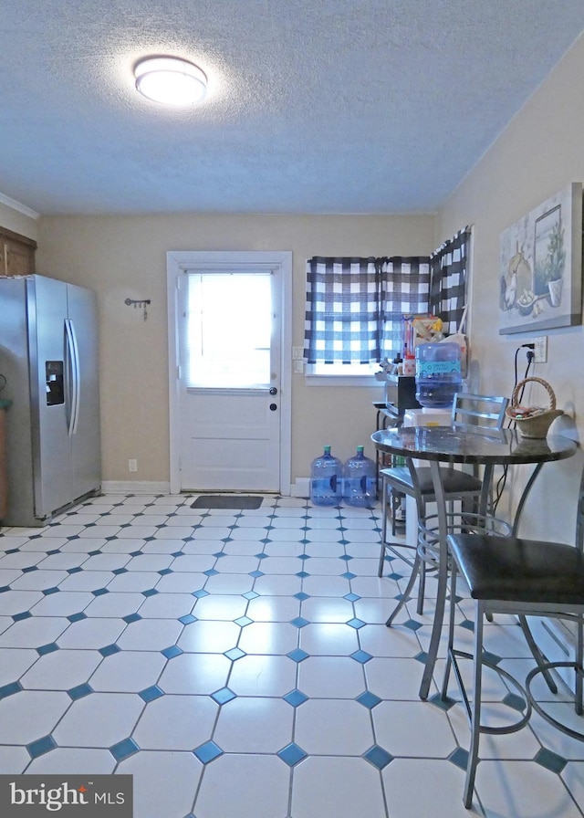 unfurnished dining area featuring a textured ceiling