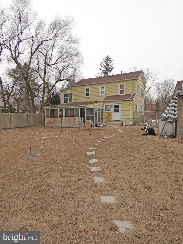 rear view of property featuring a sunroom