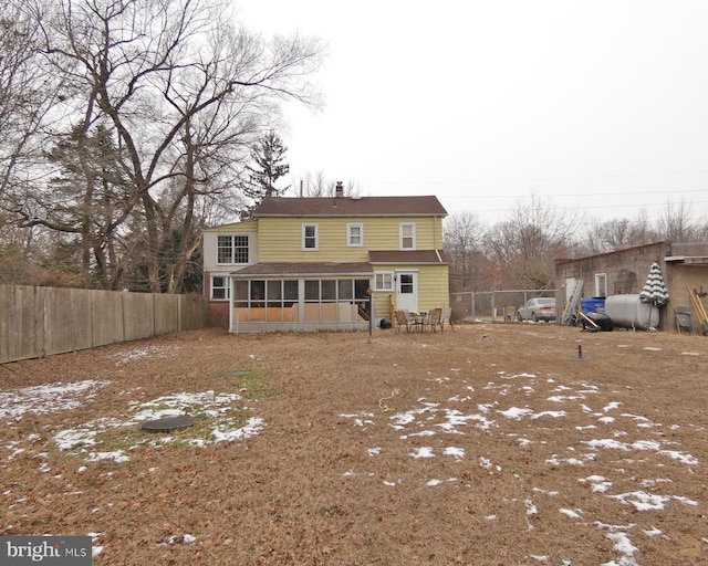 rear view of property featuring a sunroom