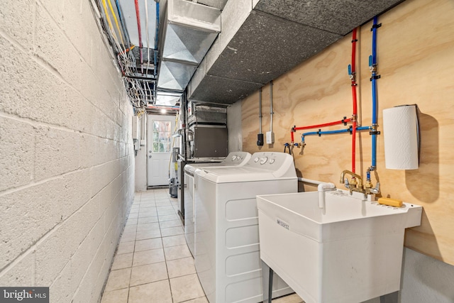 clothes washing area featuring light tile patterned floors, independent washer and dryer, and sink