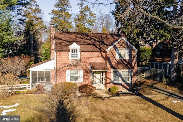 view of front of property featuring a front lawn and a sunroom