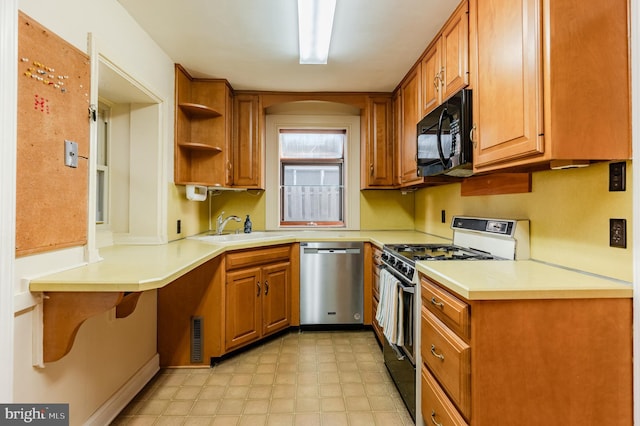 kitchen featuring gas range oven, stainless steel dishwasher, and sink