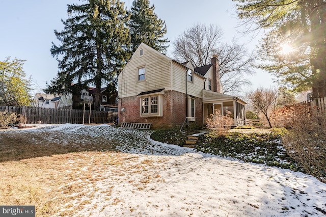 view of snowy exterior featuring a sunroom