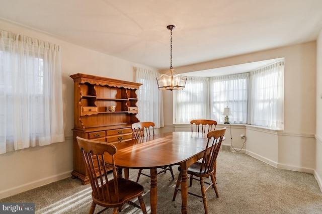 dining room featuring a notable chandelier and carpet