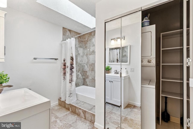 bathroom featuring vanity, stacked washer and clothes dryer, and a shower with shower curtain