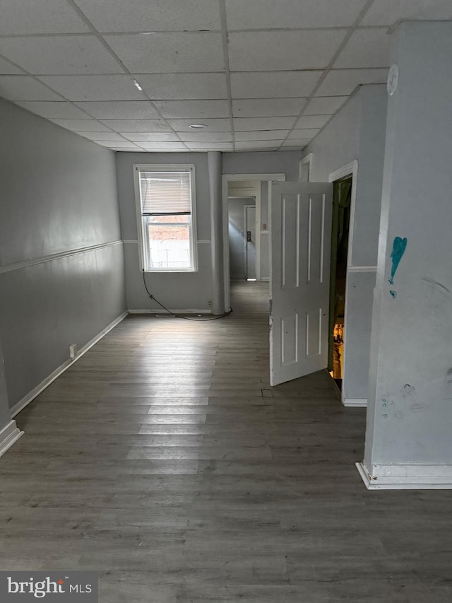 unfurnished room featuring a drop ceiling and dark wood-type flooring