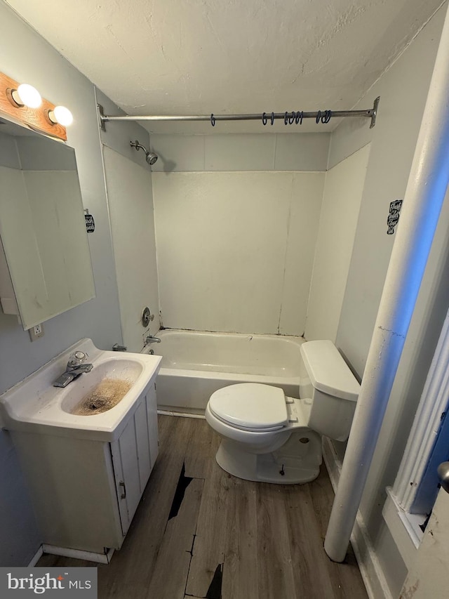 full bathroom with washtub / shower combination, vanity, wood-type flooring, and toilet