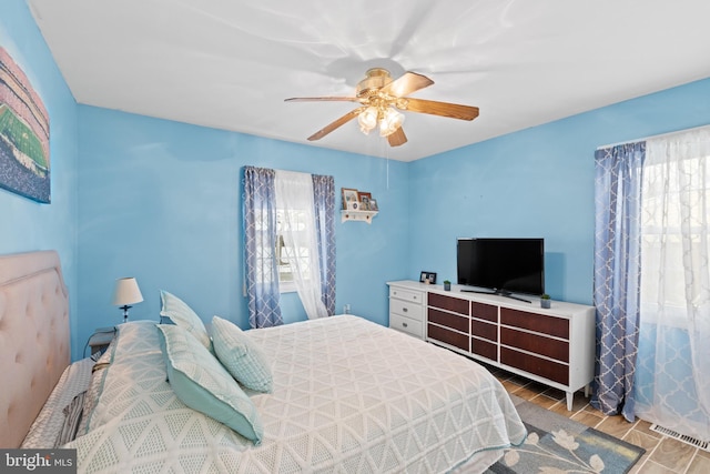 bedroom featuring multiple windows and ceiling fan