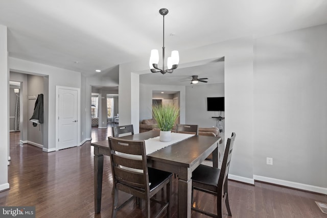 dining area featuring ceiling fan with notable chandelier and dark wood-type flooring