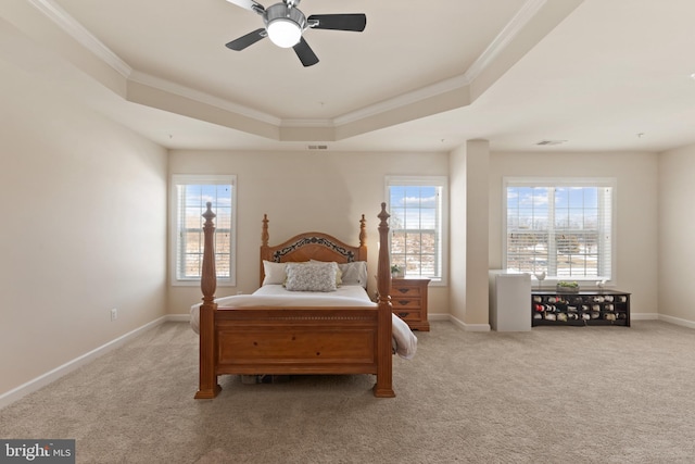 carpeted bedroom featuring ceiling fan, crown molding, and a tray ceiling