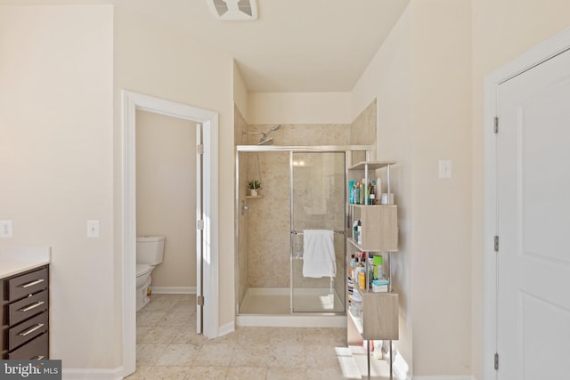 bathroom with a shower with shower door, toilet, and vanity