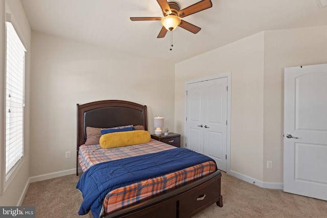 bedroom featuring ceiling fan, light colored carpet, and multiple windows