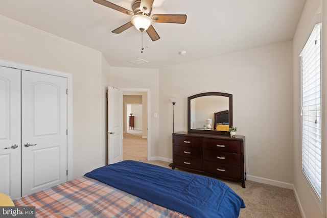 bedroom featuring ceiling fan, light colored carpet, and a closet