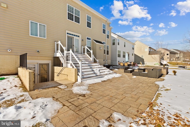 snow covered property featuring a patio area and an outdoor living space