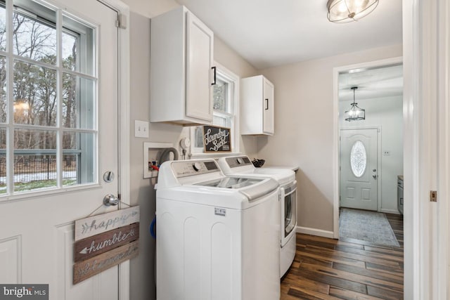 laundry room with dark wood-type flooring, cabinets, and washer and clothes dryer