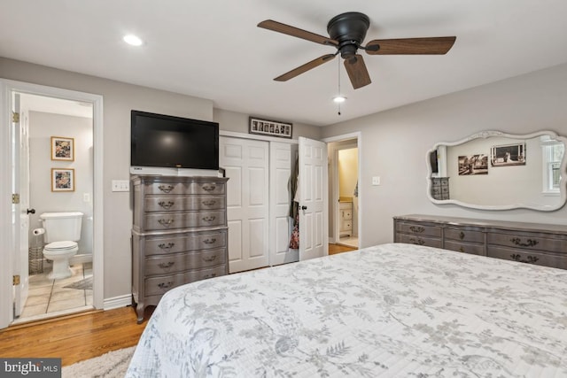 bedroom with ceiling fan, light hardwood / wood-style floors, ensuite bathroom, and a closet