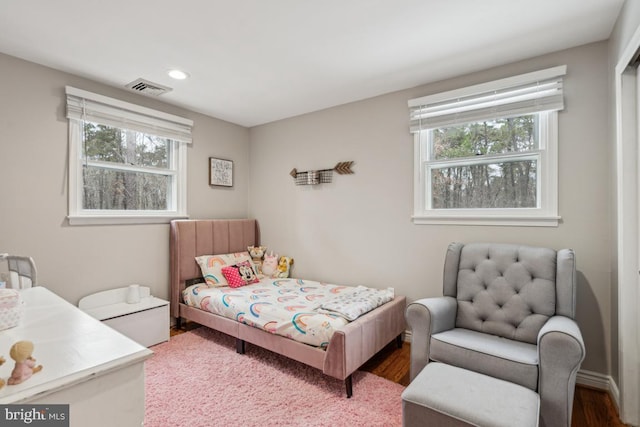 bedroom with wood-type flooring and multiple windows