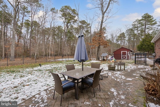 snow covered patio with a shed