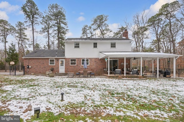 snow covered house featuring a patio and ceiling fan