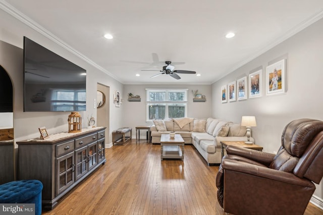 living room featuring light wood-type flooring, ceiling fan, and crown molding