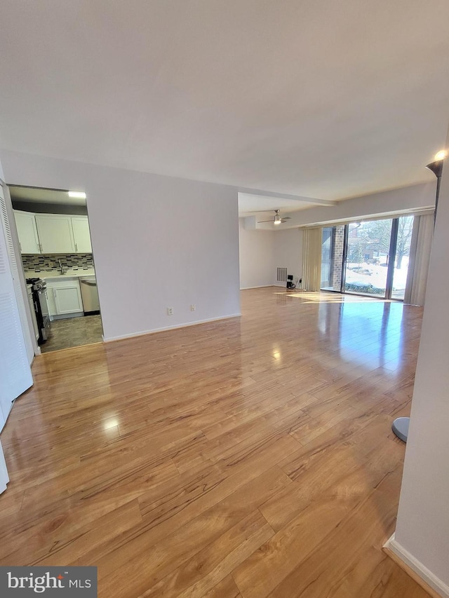 unfurnished living room with ceiling fan and light hardwood / wood-style flooring