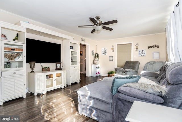 living room with dark wood-type flooring, crown molding, and ceiling fan