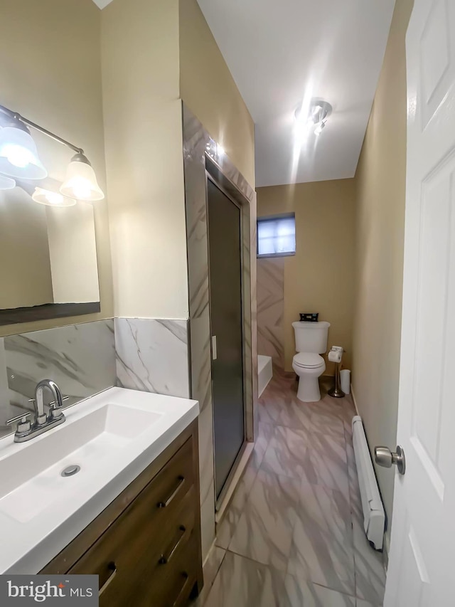 bathroom featuring backsplash, walk in shower, vanity, a baseboard heating unit, and toilet