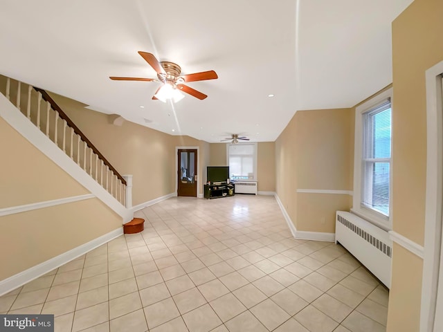 interior space with ceiling fan, radiator heating unit, and light tile patterned floors