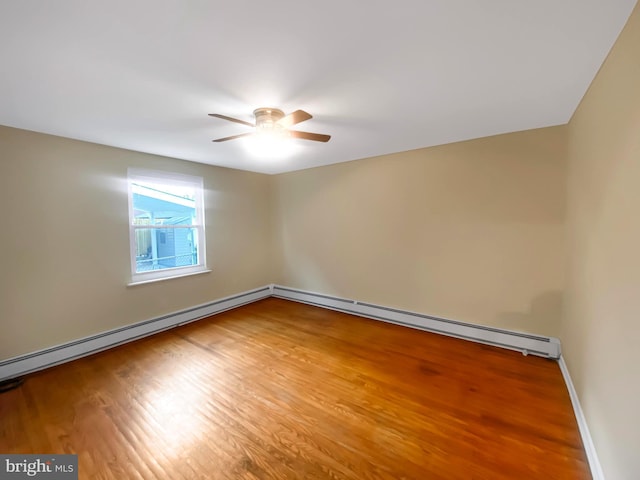 empty room featuring baseboard heating, ceiling fan, and hardwood / wood-style flooring