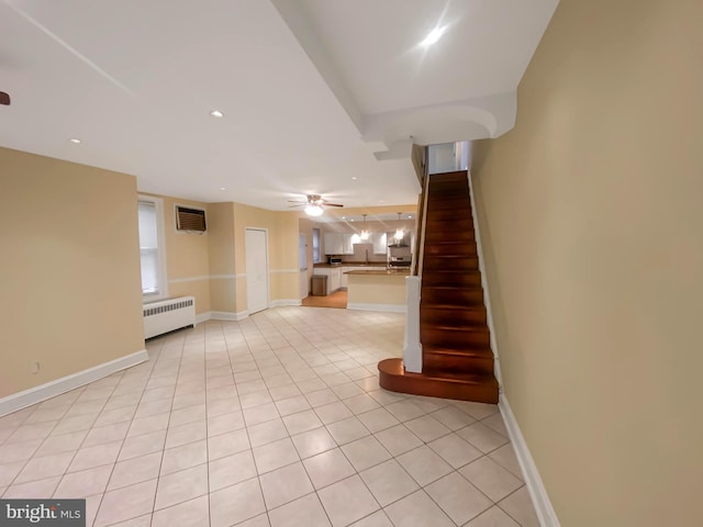 stairway with a wall mounted air conditioner, tile patterned floors, radiator, and ceiling fan