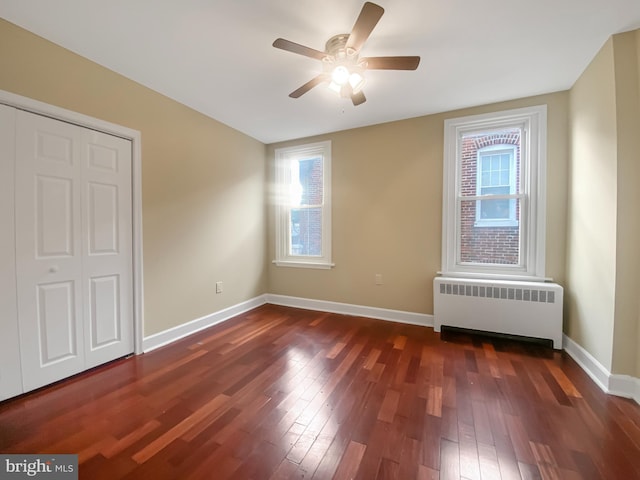 interior space with radiator heating unit, dark hardwood / wood-style floors, a wealth of natural light, and ceiling fan