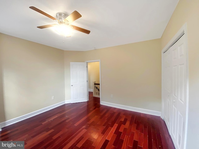 unfurnished bedroom featuring ceiling fan, dark hardwood / wood-style floors, and a closet