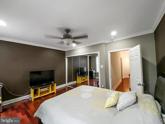 bedroom featuring ceiling fan, dark hardwood / wood-style flooring, ornamental molding, and a closet