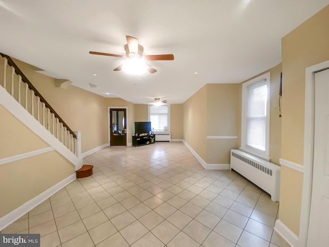 unfurnished living room featuring ceiling fan, radiator heating unit, and light tile patterned floors