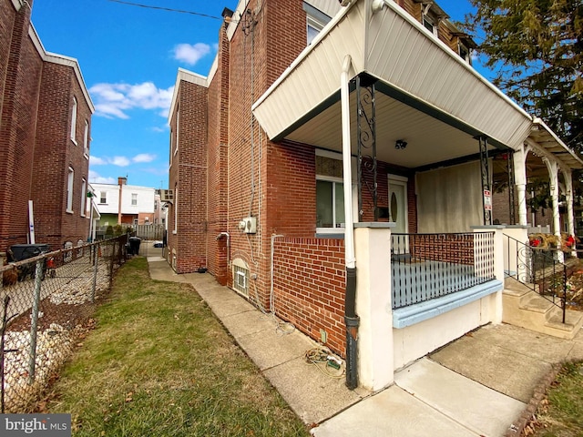 view of side of property featuring covered porch