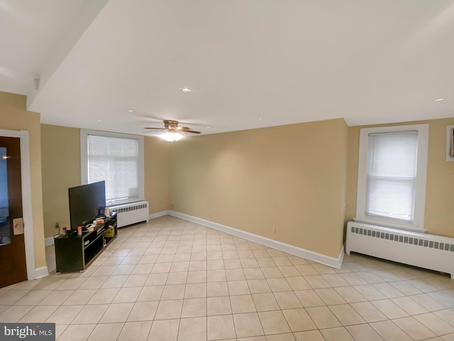 unfurnished living room featuring radiator and ceiling fan