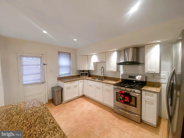 kitchen featuring backsplash, stainless steel appliances, sink, wall chimney range hood, and white cabinetry