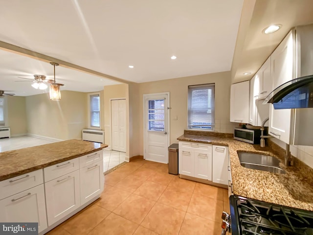 kitchen with ceiling fan, gas range oven, light tile patterned flooring, stone countertops, and white cabinets